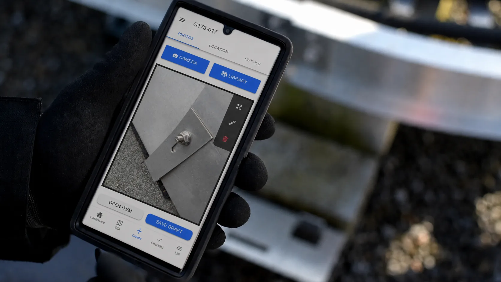 Gloved field user using Oculi to photograph site equipment