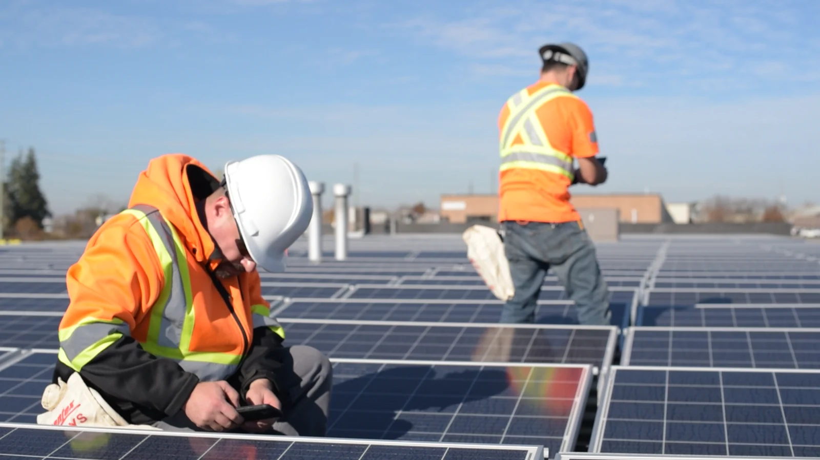 Technicians inspecting rooftop solar panels during a maintenance visit